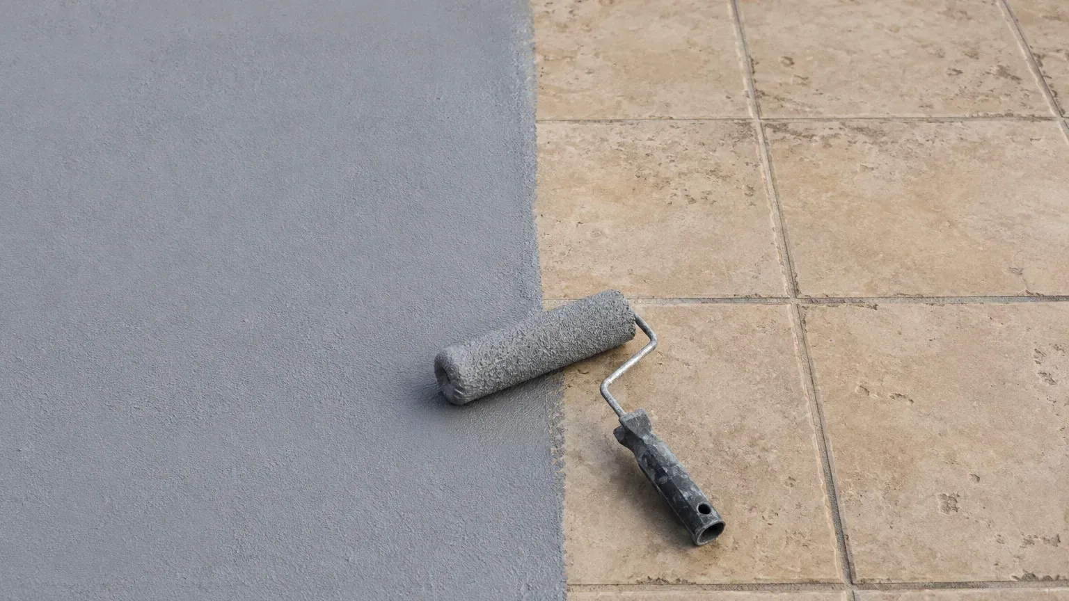 Impermeabilización gris aplicada sobre las baldosas existentes de una terraza, sin levantar el suelo